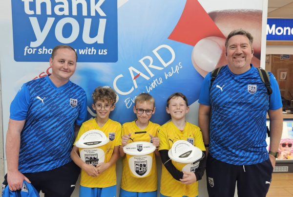 Young footballers and coaches at their local Tesco's with fundraising buckets